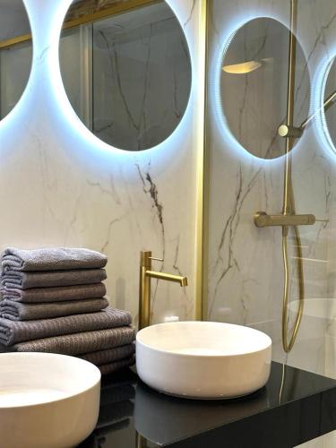 a bathroom with two sinks and two mirrors at Apartamentos Oasis de las Palmeras in Bolnuevo