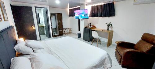 a bedroom with a bed and a couch and a television at HOTEL A & A SANTA ALEJANDRIA in Medellín