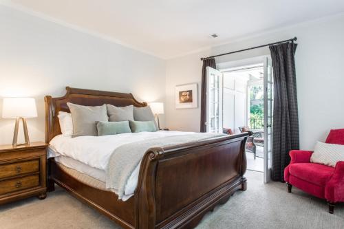 a bedroom with a large bed and a red chair at Volker at Oak Street Mansion in Kansas City