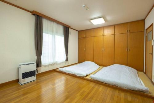 a bedroom with a large bed and a window at Stay In Miyashita in Asahikawa