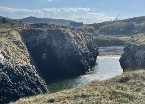 a large cave in the side of a river at An teach Illanmore in Portsalon