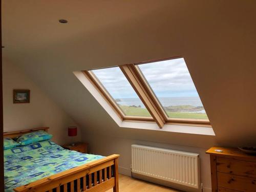 a bedroom with two skylights and a bed at An teach Illanmore in Portsalon