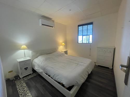Loft Vue Montagne في سان جوريوز: غرفة نوم بيضاء بها سرير ونافذة