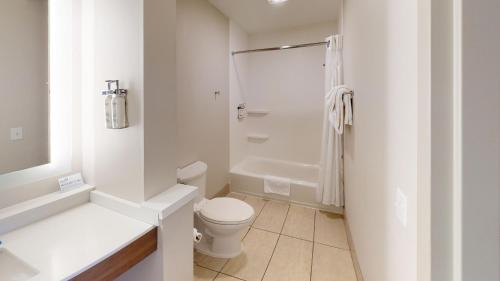 La salle de bains blanche est pourvue d'une douche et de toilettes. dans l'établissement Holiday Inn Express South Burlington, an IHG Hotel, à Burlington