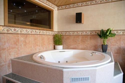 a large bath tub in a bathroom with plants at HH Huoneistot Suite in Forssa