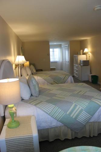 a bedroom with two beds and a table with a lamp at Red Horse Inn in Falmouth