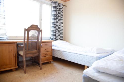 a bedroom with a desk and a bed and a chair at HH Huoneistot Suite in Forssa