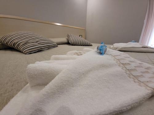 a bed with white towels on top of it at Hotel Garni Rosmari in Brenzone sul Garda
