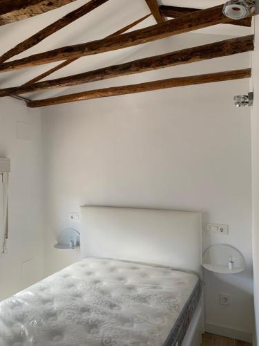 a white bedroom with a bed and a ceiling at Casa Moralzarzal jardin Sierra Madrid in Moralzarzal