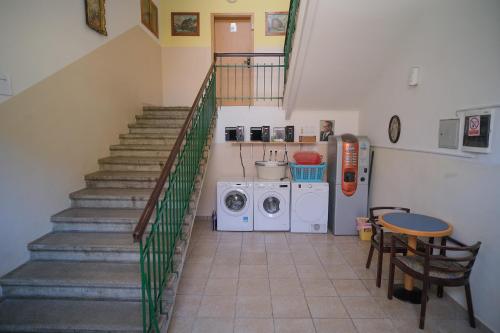 a staircase with a laundry room with a washing machine at SOSTANJ VELENJE RAVNE SOBE ROOMS Vrtacnik d o o in Šoštanj