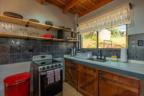 a kitchen with a stove and a sink and a window at The Red Door Mountain Cabin in Guadalupe