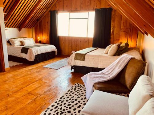 a bedroom with two beds and a window at The Red Door Mountain Cabin in Guadalupe