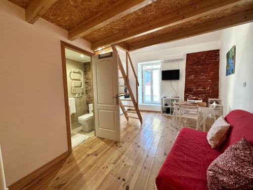 ein Wohnzimmer mit einem roten Sofa und einem Esszimmer in der Unterkunft Lovely Loft in Setúbal