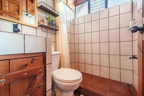 a small bathroom with a toilet and a window at The Red Door Mountain Cabin in Guadalupe