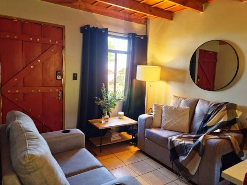 a living room with a couch and a chair and a mirror at The Red Door Mountain Cabin in Guadalupe