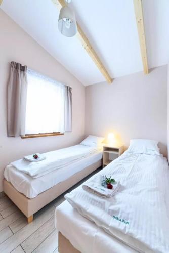 een slaapkamer met 2 bedden en een raam bij Dolina Bugu Kodeń in Kodeń