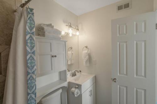 a bathroom with a sink and a toilet and a mirror at Jubilee Landing 110 by Vacation Homes Collection in Orange Beach