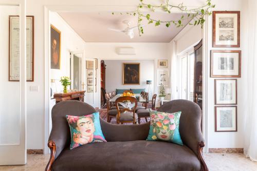 a living room with a brown chair with pillows at Libertà #102 - Guest House Palermo in Palermo