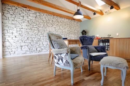 a living room with chairs and a stone wall at CASA OPICINA - Elegante appartamento in VILLA CARSICA in Villa Opicina