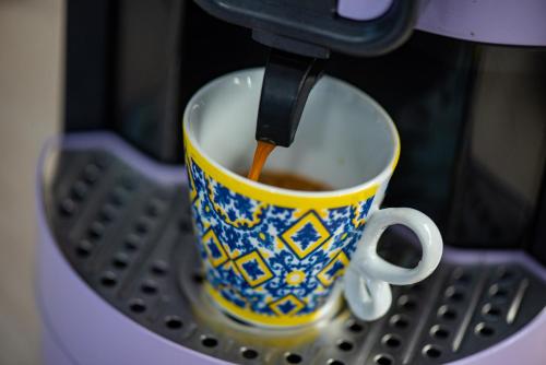 a cup of coffee being brewed in a coffee machine at Casa La Conchiglia in Sciacca