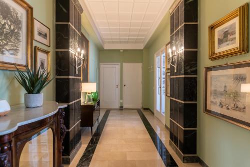 a hallway with a tile accent wall and a console table at Libertà #102 - Guest House Palermo in Palermo