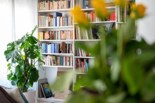 a book shelf filled with books in a living room at Libertà #102 - Guest House Palermo in Palermo