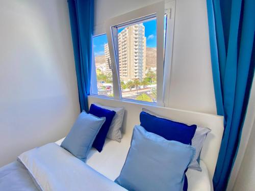 een kamer met een bank en een raam met blauwe gordijnen bij ANNA beautiful apartment in the first Oceanline in Los Cristianos. in Los Cristianos