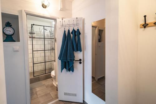 uma casa de banho com WC e uma porta branca em LénApartman - Marilyn em Pécs