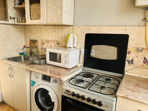 a kitchen with a stove and a microwave at Apartment on Bagratuniats Street in Yerevan