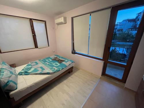 a small bedroom with a bed and a window at Vqra Sarafovo in Burgas