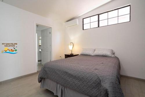 une chambre avec un grand lit et une fenêtre dans l'établissement Beautiful San Felipe in town home, à San Felipe