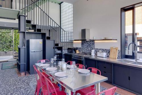 uma cozinha com uma mesa e cadeiras vermelhas em Escape 2 the City NEW apartment 3bed Highgate Hill em Brisbane
