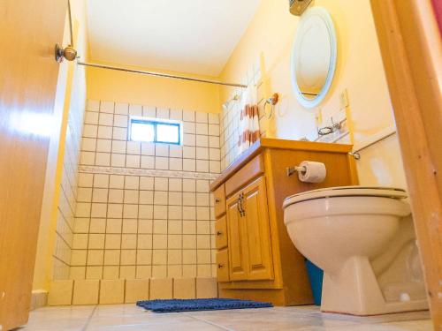a bathroom with a toilet and a sink and a mirror at 2BR 2BA Family Vacation Home with WiFi in San Felipe