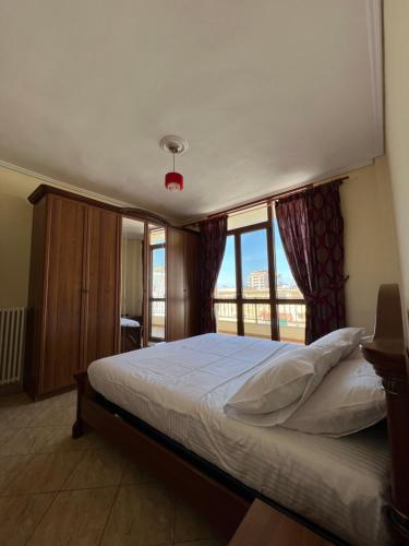 una camera con un letto e una grande finestra di Apartament Vanesa a Vlorë