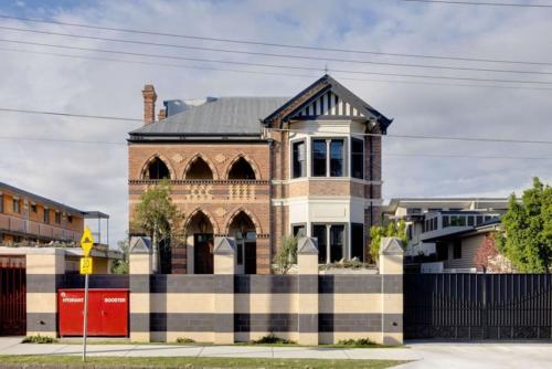 un edificio de ladrillo con una valla negra delante de él en NEW 3Bed Apartment Highgate Hill en Brisbane