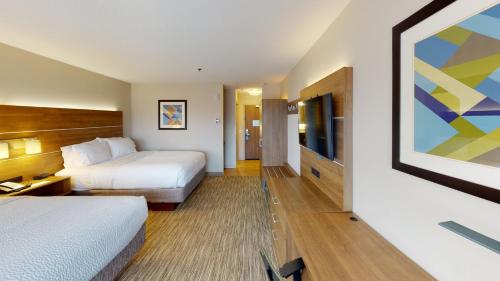 a hotel room with two beds and a flat screen tv at Holiday Inn Express South Burlington by IHG in Burlington