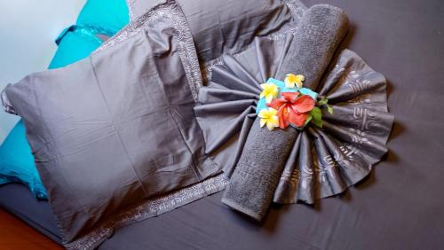 a dress with a flower on top of a bed at AquaLodge Fakarava in Rotoava
