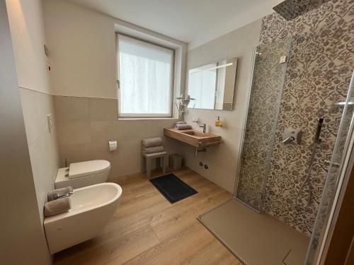 a bathroom with a toilet and a sink and a shower at Le Rocce Val di Non - Quality Room & Breakfast in Tassullo