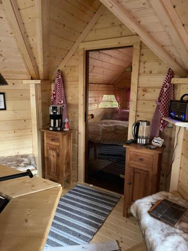 a log cabin with a bed and a door into a room at Grillkota Holzhütte in Lauenburg