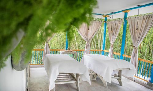 two tables and chairs on a balcony with curtains at Hotel Hacienda Santa Clara in Santa Rosa de Cabal