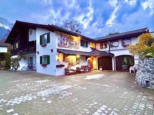 a large house with a patio in front of it at Hotel Bergland in Grainau