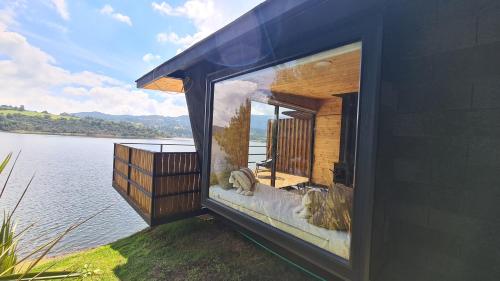 a large window of a house on the water at GLAMPING BY NAQUA in Pantano Redondo