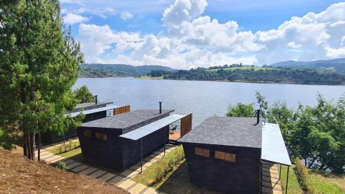 a house on the side of a lake at GLAMPING BY NAQUA in Pantano Redondo