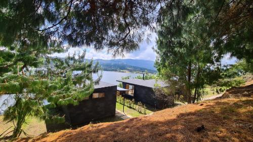 a house on a hill next to a lake at GLAMPING BY NAQUA in Pantano Redondo