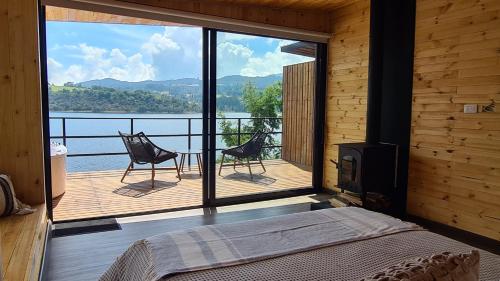 a bedroom with a balcony with a view of the water at GLAMPING BY NAQUA in Pantano Redondo