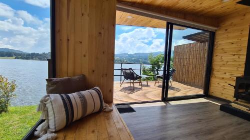 a cabin with a deck with a view of the water at GLAMPING BY NAQUA in Pantano Redondo
