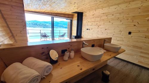 a bathroom with two sinks and a large window at GLAMPING BY NAQUA in Pantano Redondo