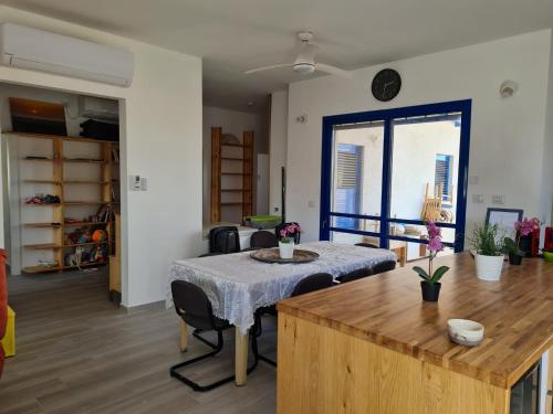 a room with a table and chairs and a large window at Yvonne Hostel Sde Boker in Midreshet Ben Gurion