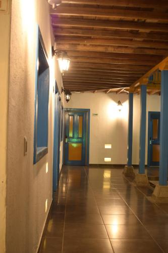 an empty hallway with blue columns and blue doors at Hotel Hacienda Santa Clara in Santa Rosa de Cabal