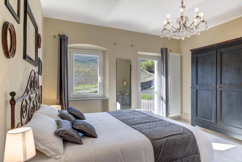 a bedroom with a large bed with pillows and a chandelier at Ciabot delle Aie - Barolo in Barolo